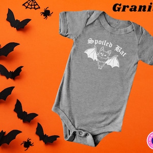 May include: A gray baby onesie with a white graphic of a bat with the text "Spoiled Bat" in a gothic font.