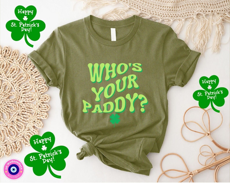 May include: A green t-shirt with the text "WHO'S YOUR PADDY?" in a retro font. The shirt is surrounded by shamrocks with the text "Happy St. Patrick's Day!"