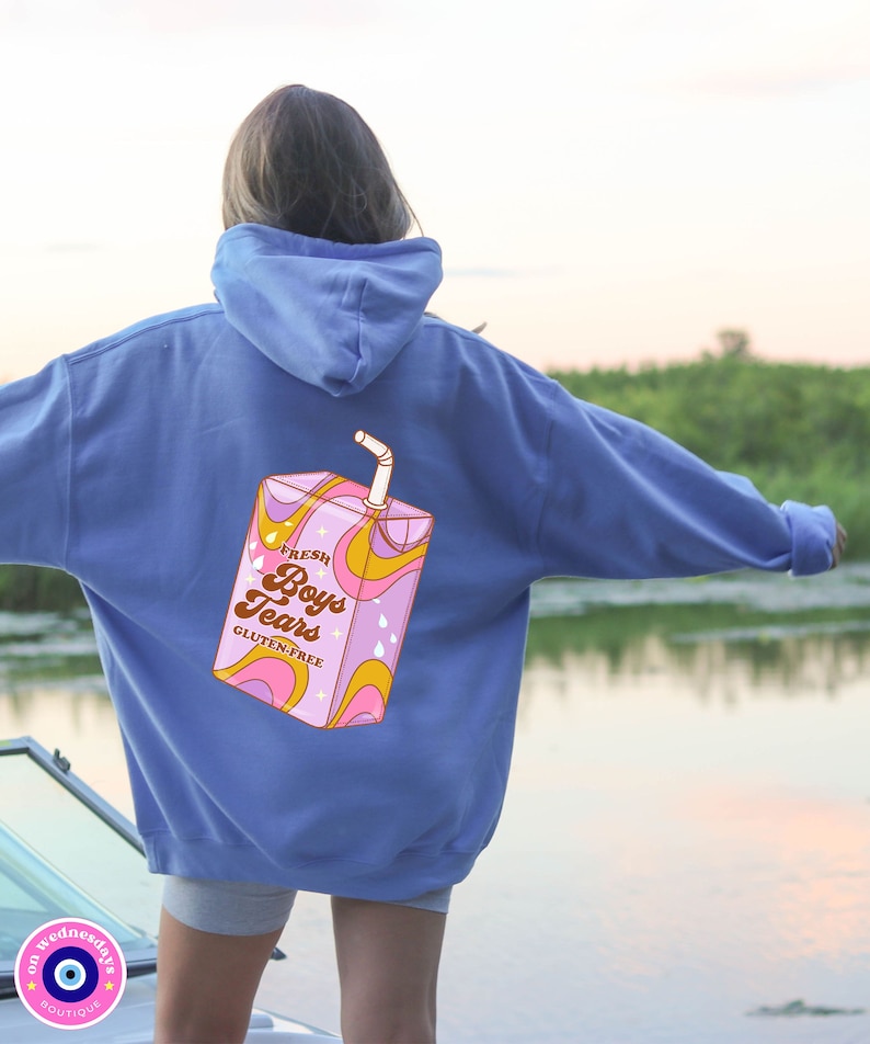 May include: A blue hoodie with a graphic of a pink and yellow juice box with the text "Fresh Boys Tears Gluten-Free" on the back.