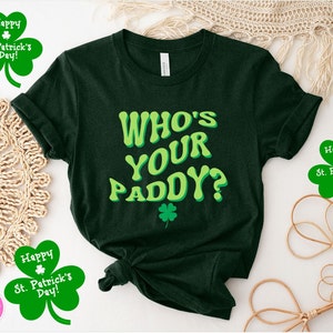 May include: A dark green t-shirt with the text "WHO'S YOUR PADDY?" in a green and yellow font. The shirt is decorated with a green shamrock.