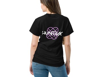 May include: Black t-shirt featuring the word "HUNTRX" in white, with a pink geometric design on the back. The shirt has a crew neck and is worn with blue jeans.
