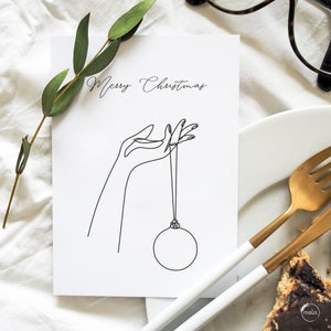 Cartolina di Natale Oneline n. 2 "Mano con palla dell'albero di Natale" – Biglietto d'auguri (Grammatura 400g/m2) #female #grafik #modern #organic