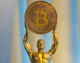 Statue of Bitcoin Man holding a token of the cryptocurrency bitcoin - symbol of financial freedom and digital gold