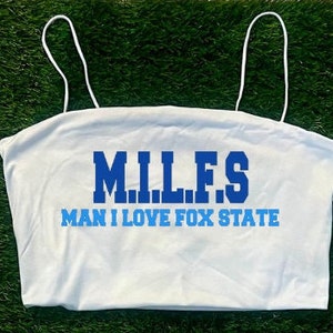 May include: White crop top with blue text that reads "M.I.L.F.S. Man I Love Fox State"