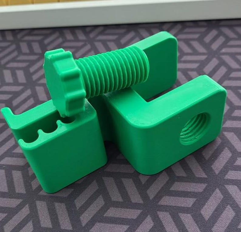 Puede incluir: Un juego de tornillos y soportes impresos en 3D de color verde brillante. El tornillo tiene una cabeza hexagonal y un v&aacute;stago roscado. Los soportes tienen un agujero y una ranura para que encaje el tornillo. El juego est&aacute; dise&ntilde;ado para aplicaciones mec&aacute;nicas o de construcci&oacute;n.