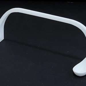 May include: White plastic stand with two curved arms, designed to hold a pair of glasses or other items.