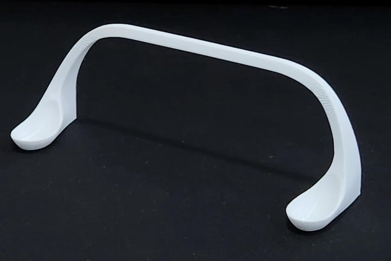 May include: White plastic stand with two curved arms, designed to hold a pair of glasses or other items.