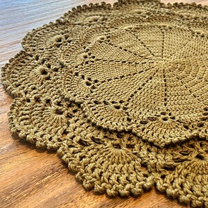 May include: Close-up of several handmade, round crochet doilies in a warm, earthy tone. The doilies feature a detailed, openwork design with scalloped edges. The texture of the yarn is visible, adding to the handcrafted aesthetic.