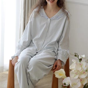 Peut inclure: Ensemble de pyjama à rayures bleu clair avec un col festonné. Le haut à manches longues a des boutons et le pantalon est de couleur assortie. L'ensemble est fait d'une matière douce et confortable. Le pyjama est conçu pour la détente et le sommeil.