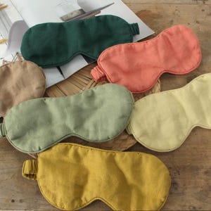 Puede incluir: Una colección de antifaces para dormir en varios colores, incluyendo verde, melocotón, amarillo y beige. Las máscaras están hechas de tela suave y tienen una banda elástica para un ajuste cómodo. Diseñadas para bloquear la luz y mejorar el sueño.