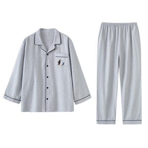 May include: Light gray pajama set with a button-down shirt and matching pants. The shirt features a small embroidered design of two birds. The set has black trim and is made of a soft, comfortable material.