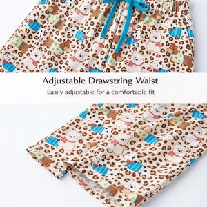 May include: Tan pajama pants with a repeating pattern of white polar bears, brown bears, and dalmatians, accented with blue and yellow details. The pants have an adjustable drawstring waist and a relaxed fit leg opening.