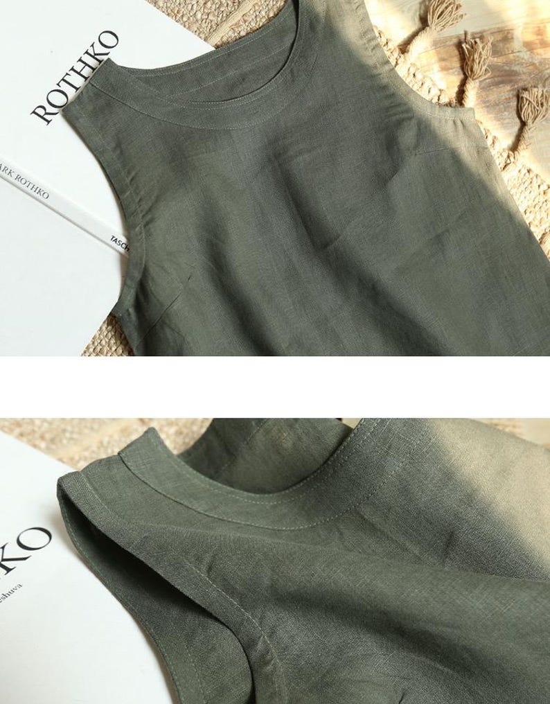May include: A sleeveless, olive green linen top with a round neckline. The fabric has a slightly textured appearance. The top is displayed on a neutral background, with the word "ROTHKO" visible on a book in the background.