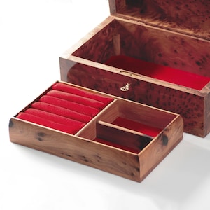 May include: A wooden jewelry box with a red velvet interior. The box has a hinged lid and a pull-out drawer with compartments for rings and other small items.