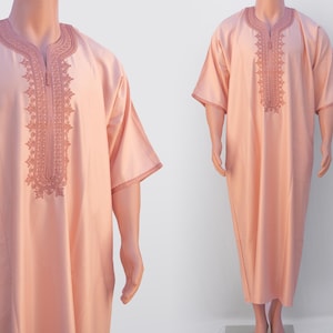May include: A long-sleeved, peach-colored robe with intricate embroidery on the front. The robe has a V-neck and short sleeves.