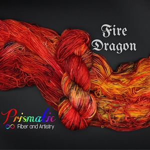 May include: A skein of yarn in shades of red, orange, and yellow, with black accents. The yarn is called "Fire Dragon" and is from the company "Prismatic Fiber and Artistry".