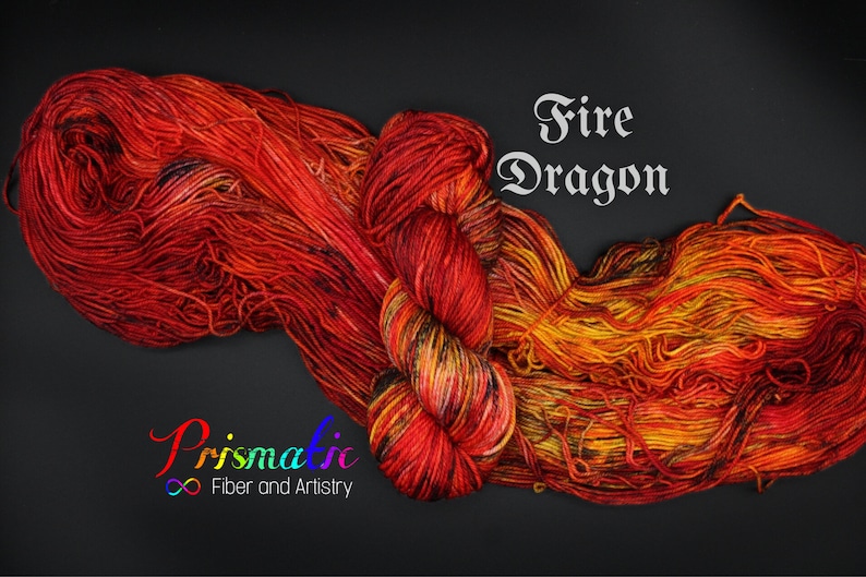 May include: A skein of yarn in shades of red, orange, and yellow, with black accents. The yarn is called "Fire Dragon" and is from the company "Prismatic Fiber and Artistry".