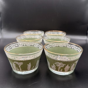 May include: Set of six vintage glass dessert bowls. Each bowl features a sage green interior with a white and gold rim. The exterior has a white decorative band with a classical scene. The bowls are ideal for serving desserts.