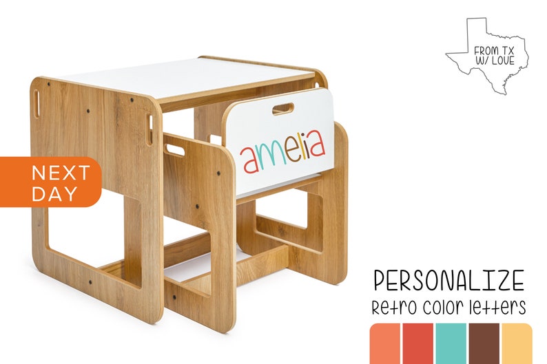 May include: A wooden children's table and chair set with a white top. The chair has a cutout for a child to hold onto. The table has a white surface with the name "amelia" written in colorful letters. The set is made in Texas.