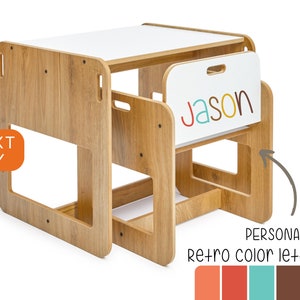 May include: Wooden children's table and chair set with a white top and a personalized nameplate that says "Jason" in colorful letters. The chair has a built-in storage compartment. The table and chair are made of natural wood with a light brown finish.