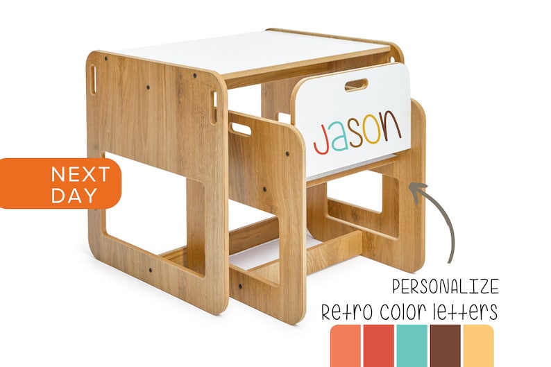 May include: Wooden children's table and chair set with a white top and a personalized nameplate that says "Jason" in colorful letters. The chair has a built-in storage compartment. The table and chair are made of natural wood with a light brown finish.