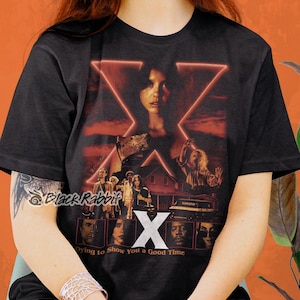 Camiseta clásica unisex inspirada en el póster de la película de terror "X Mia Goth" que se muere por mostrarte un buen momento.