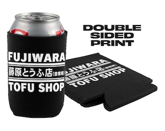 Op de afbeelding: Een zwarte neopreen-blikjeskoeler met witte tekst die "FUJIWARA 勝原とうふ店(自家用) TOFU SHOP" aan de ene kant en "FUJIWARA 藤原とうふ店(自家用) TOFU SHOP" aan de andere kant zegt. De tekst is aan beide kanten van de koeler gedrukt. De koeler is ontworpen om te passen op een standaard blikje van 355 ml.