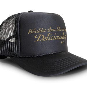 May include: Black trucker hat with a mesh back and a curved brim. The front of the hat features the gold text, "Wouldst thou like to live deliciously?"