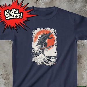 May include: Navy blue t-shirt featuring a Godzilla-like monster surfing a large wave with a red sun in the background. The text "Kid's Sizes!" is in a red starburst shape in the top left corner.