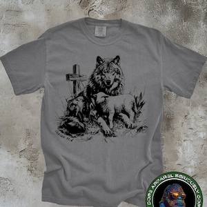 May include: A gray t-shirt with a black and white graphic of a wolf, a lamb, and a cross. The text "ISAIAH 11:6" is printed below the graphic.