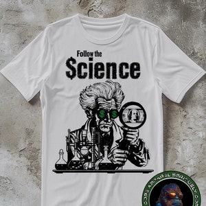 May include: White t-shirt with a black and white illustration of a scientist wearing glasses with dollar signs in the lenses. The scientist is looking through a magnifying glass at a dollar bill. The text "Follow the Science" is printed above the illustration. The t-shirt has a small logo on the bottom right corner.