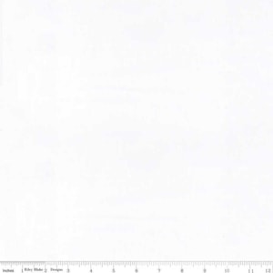 May include: A white fabric with a ruler along the bottom edge, marked in inches. The ruler starts at 0 inches and extends to 12 inches. The text "Riley Blake Designs" is printed on the fabric.