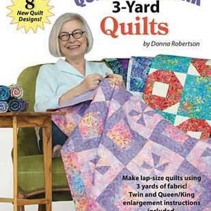 May include: A book cover titled "QUICK AS A WINK 3-Yard Quilts" by Donna Robertson. The cover features a woman holding a purple and pink quilt. The book promises lap-size quilts using 3 yards of fabric.