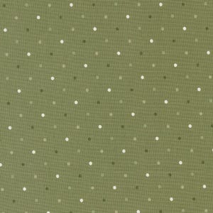May include: Close-up of a green fabric with a repeating pattern of small, evenly spaced polka dots in shades of white, gray, and olive green. The fabric has a textured appearance, suggesting a woven material.