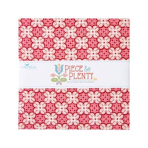 May include: A stack of fabric squares with a repeating floral pattern in shades of pink and red. A white band across the center displays the text "PIECE & PLENTY" and the Riley Blake Designs logo. The fabric is likely for quilting or other sewing projects.
