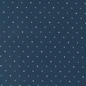 May include: A close-up of a navy blue fabric with a repeating pattern of small, evenly spaced polka dots. The dots are in shades of white and light blue, creating a subtle contrast against the dark background. The fabric has a textured appearance.
