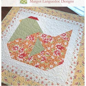 May include: A quilted nesting table topper with a bird design. The bird's body is orange with red floral patterns, and the head is green with white dots. The table topper measures 28 inches by 30 inches.