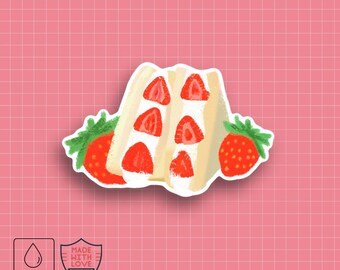 Puede incluir: Una pegatina impermeable con un sándwich de fresas con rodajas rojas de fresa y un relleno cremoso. Dos fresas enteras con hojas verdes flanquean el sándwich. La pegatina incluye el texto "MADE WITH LOVE".