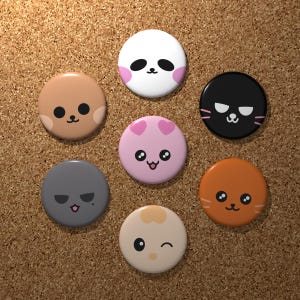 Può includere: Una collezione di sette bottoni rotondi e colorati con facce di animali dei cartoni animati. I bottoni presentano un panda, un gatto, un cane e altri simpatici personaggi in vari colori, tra cui bianco, rosa, marrone, grigio e arancione. I bottoni sono disposti su una superficie di sughero.