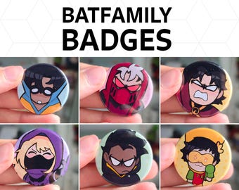 May include: Circular badges featuring various characters from the Batfamily. Each badge displays a different character with unique color schemes and expressions. The text "BATFAMILY BADGES" is at the top. These badges are likely collectible items or accessories.