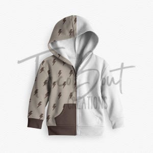 May include: A brown and white zippered hoodie with a brown lightning bolt pattern on one side and a solid white side. The hoodie has a brown pocket on the front.