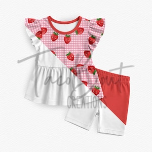 Puede incluir: Un conjunto de dos piezas para niños con un diseño de bloques de color blanco y rojo. La parte superior tiene un estampado de cuadros rosas con gráficos de fresas. Los pantalones cortos son rojos y blancos. El conjunto está diseñado para niños.