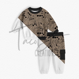 May include: A two-piece children's outfit featuring a brown and black patterned top and white pants. The top has a crew neck and long sleeves with a repeating pattern of sunglasses, cherries, and the words "Cool Crew" and "Rad". The white pants have a black pocket.