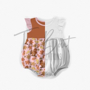 May include: A white and pink baby onesie with a brown and orange squirrel and leaf pattern on the bottom half. The top half is a solid brown color.