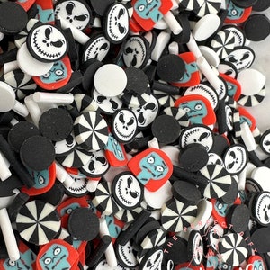Puede incluir: Una colección de abalorios de arcilla polimérica negra, blanca y roja con personajes de Pesadilla Antes de Navidad. Los abalorios incluyen la cara de Jack Skellington, la cara de Sally y un diseño de bastón de caramelo.