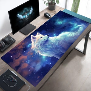 May include: A white wolf with blue eyes is depicted on a blue and purple galaxy-themed mousepad. The wolf is looking to the right and has a soft, fluffy appearance. The mousepad is decorated with white stars and a nebula.