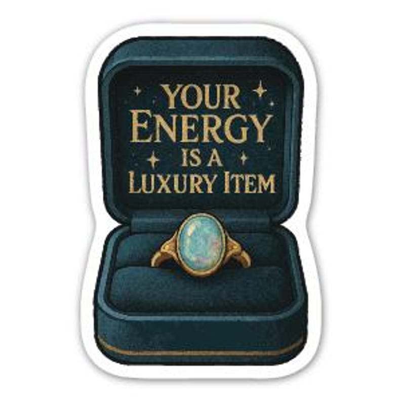 May include: A sticker featuring a teal ring box with gold accents, open to reveal a gold ring with a light blue oval stone. The text "YOUR ENERGY IS A LUXURY ITEM" is in gold lettering above the ring.