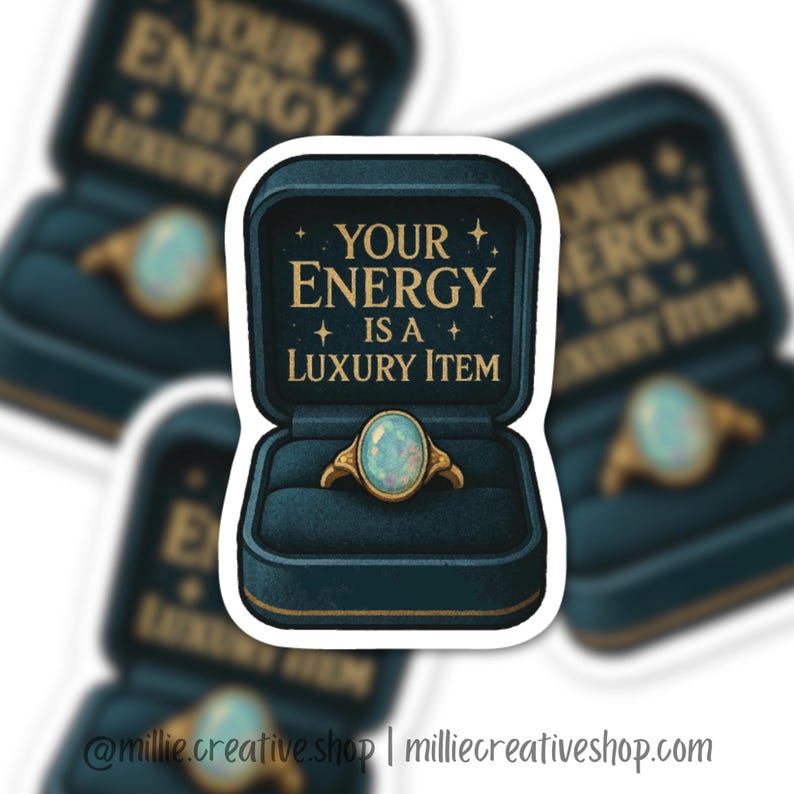 May include: A sticker featuring a gold ring with a light blue oval gemstone inside a teal ring box. The box has the text "YOUR ENERGY IS A LUXURY ITEM" in gold lettering. The sticker has a white border.
