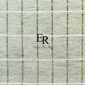 Könnte beinhalten: Nahaufnahme eines strukturierten Teppichs mit einem hellgrünen und weißen Karomuster. Vertikale und horizontale Linien kreuzen sich und bilden ein Rastermuster. Der Text "ER Exotic Fine Rugs" ist schwarz zentriert.