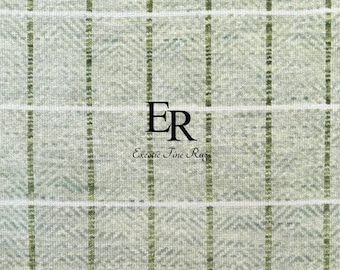 May include: Close-up of a textured rug with a light green and white plaid pattern. Vertical and horizontal lines intersect, creating a grid design. The text "ER Exotic Fine Rugs" is centered in black.